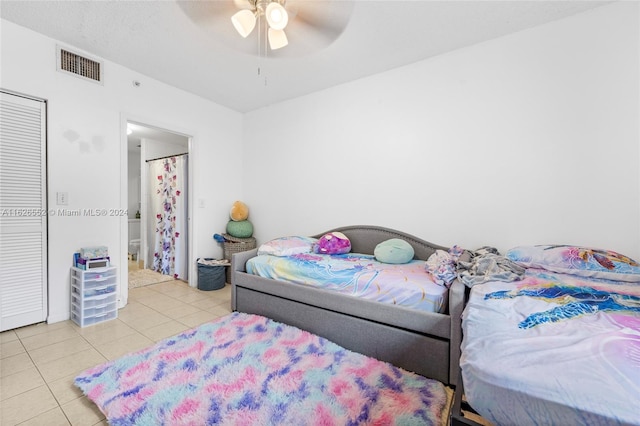 tiled bedroom featuring ceiling fan