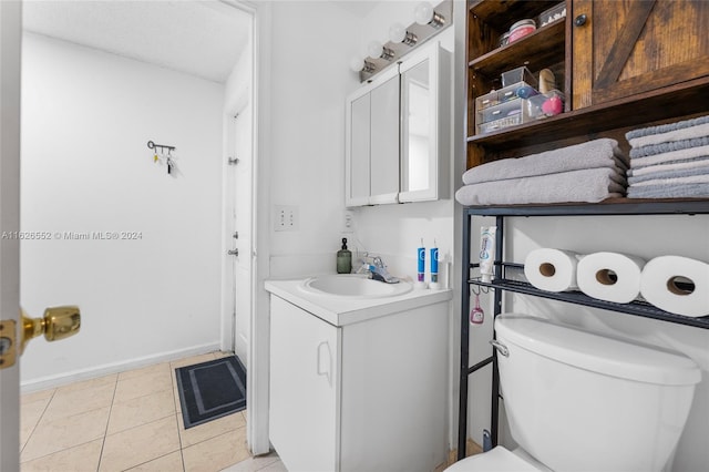 bathroom featuring vanity, tile patterned flooring, and toilet