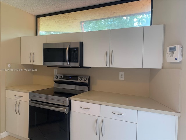 kitchen featuring white cabinetry, appliances with stainless steel finishes, and a textured ceiling