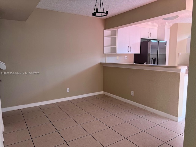 kitchen featuring white cabinets, stainless steel refrigerator with ice dispenser, decorative light fixtures, and light tile patterned floors