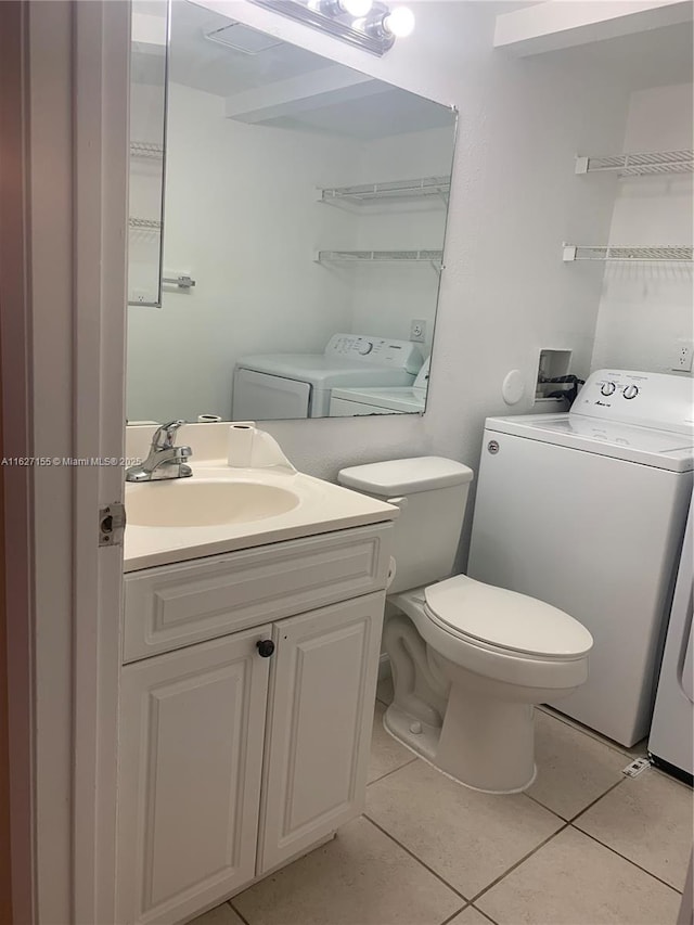 bathroom with tile patterned flooring, vanity, separate washer and dryer, and toilet