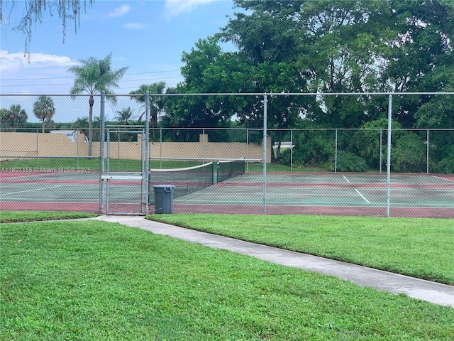 view of tennis court featuring a lawn