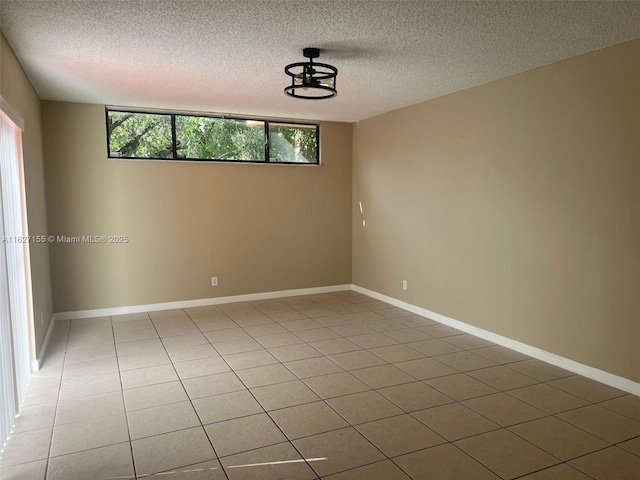 empty room with tile patterned flooring, plenty of natural light, and a textured ceiling