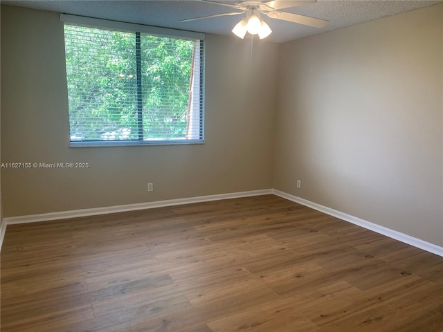 unfurnished room featuring hardwood / wood-style floors, ceiling fan, and a textured ceiling