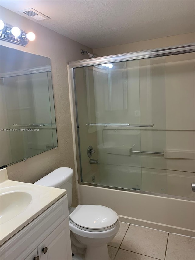 full bathroom with tile patterned flooring, enclosed tub / shower combo, a textured ceiling, toilet, and vanity