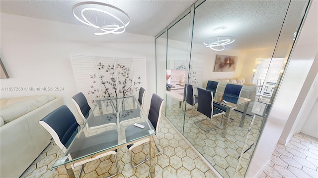 dining room featuring a textured ceiling, a chandelier, and light tile patterned flooring