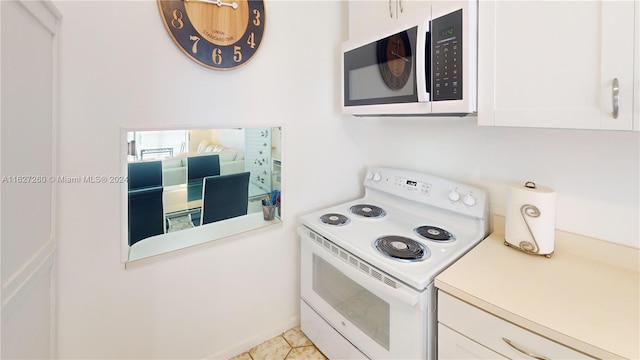 kitchen featuring white cabinetry, white appliances, and light tile patterned flooring