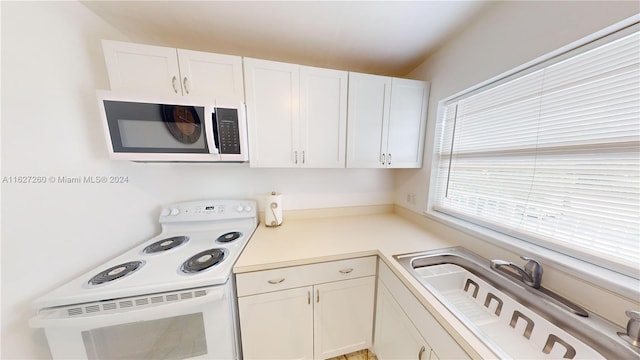 kitchen with white cabinetry, sink, and electric range