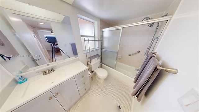 full bathroom featuring vanity, tile patterned floors, combined bath / shower with glass door, and toilet