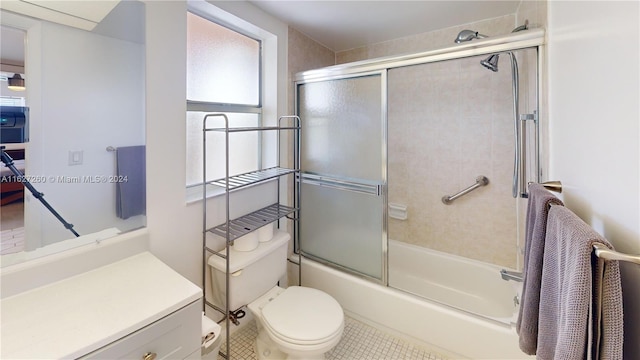 full bathroom with vanity, enclosed tub / shower combo, and toilet