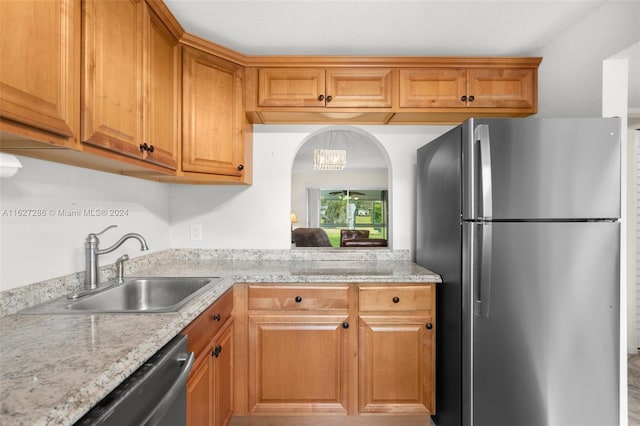 kitchen with sink, light stone counters, and stainless steel appliances