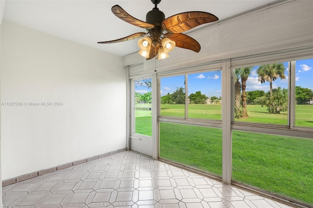 unfurnished sunroom with ceiling fan