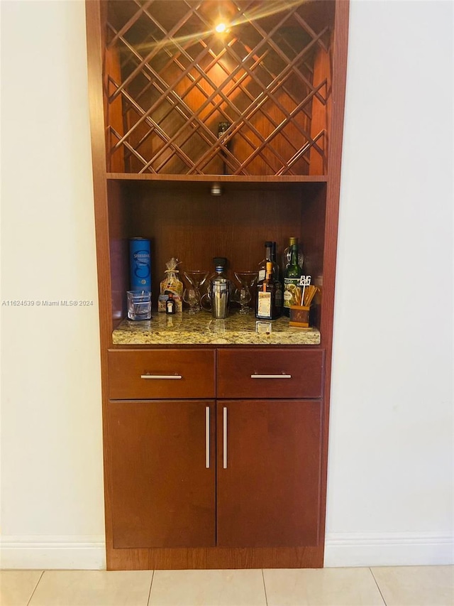 bar featuring light stone countertops and light tile patterned floors