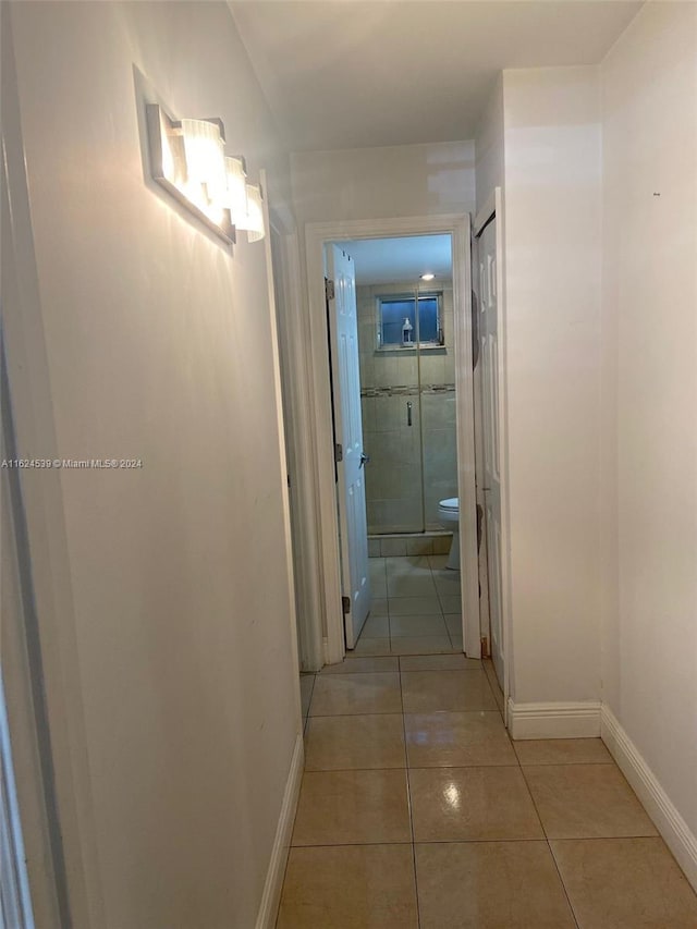 hall featuring light tile patterned floors