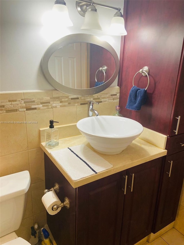 bathroom featuring tile patterned flooring, tile walls, backsplash, toilet, and vanity