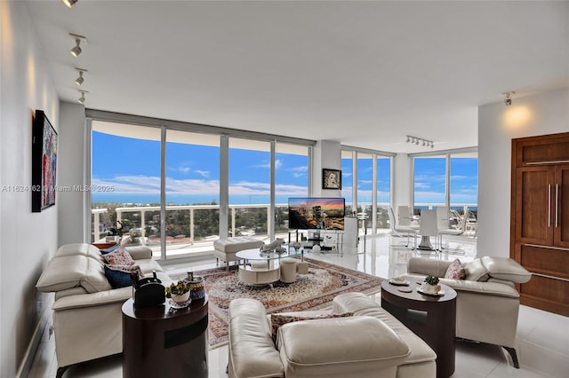 living room with expansive windows, a healthy amount of sunlight, rail lighting, and light tile patterned floors