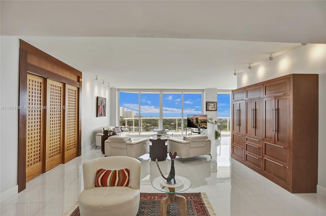 living room with floor to ceiling windows, rail lighting, and light tile patterned floors