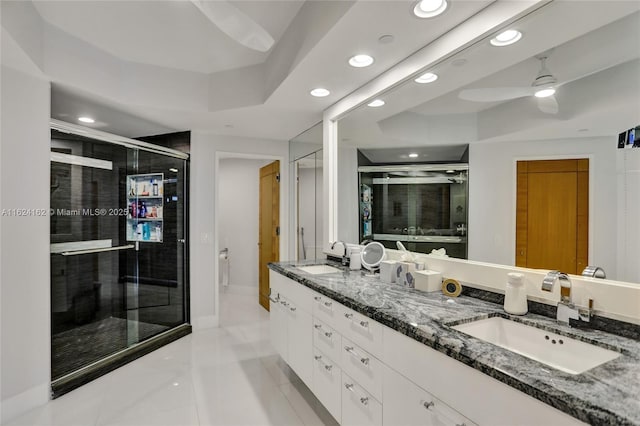 bathroom featuring recessed lighting, a sink, a shower stall, and double vanity