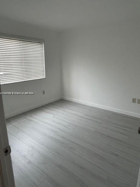 unfurnished room with hardwood / wood-style floors