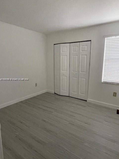 unfurnished bedroom featuring light wood-type flooring and a closet