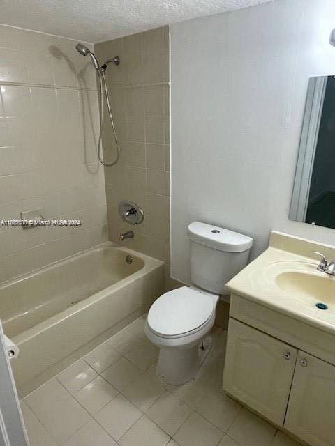 full bathroom featuring a textured ceiling, tiled shower / bath, tile patterned floors, vanity, and toilet