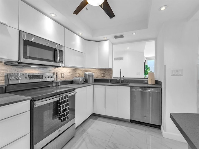 kitchen featuring ceiling fan, white cabinets, sink, appliances with stainless steel finishes, and light tile patterned floors