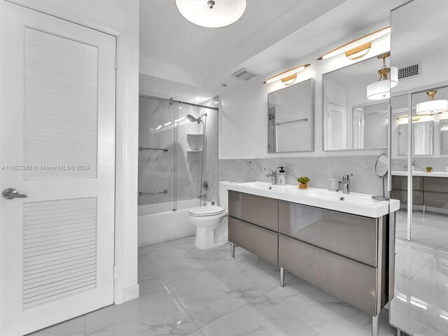 full bathroom with toilet, tiled shower / bath, tile patterned flooring, and dual bowl vanity