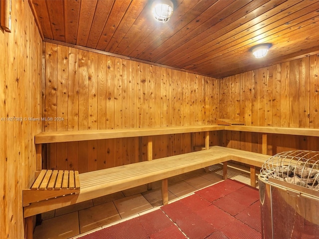 view of sauna with wood ceiling, tile patterned flooring, and wooden walls