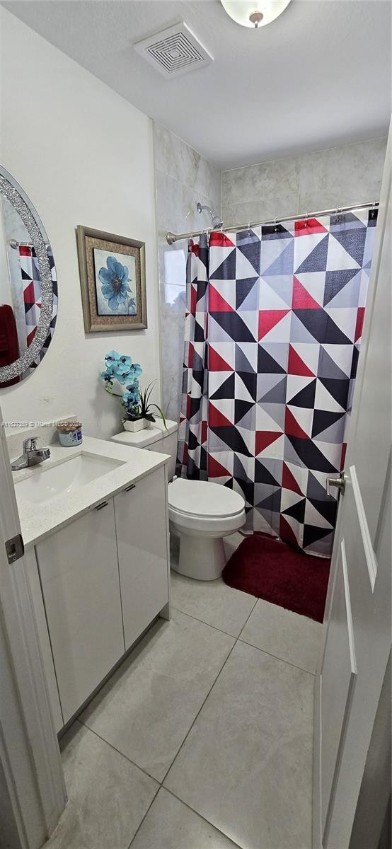 bathroom featuring vanity, tile patterned floors, and toilet