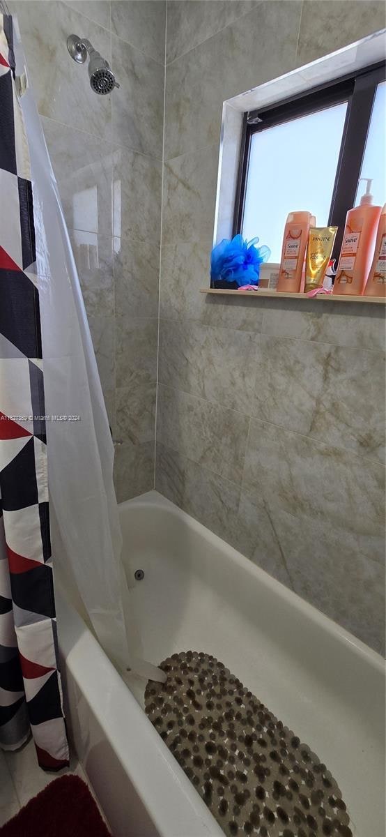 bathroom with tile patterned flooring and shower / bath combo