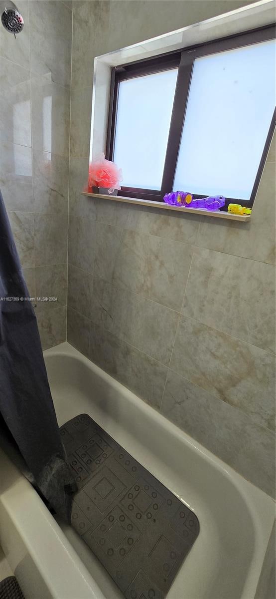 bathroom featuring tiled shower / bath