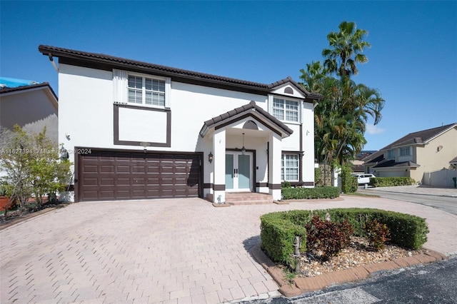 7949 NW 188th Ter, Hialeah, FL 33015 - mediterranean / spanish home featuring french doors, an attached garage, decorative driveway, stucco siding, and a tile roof