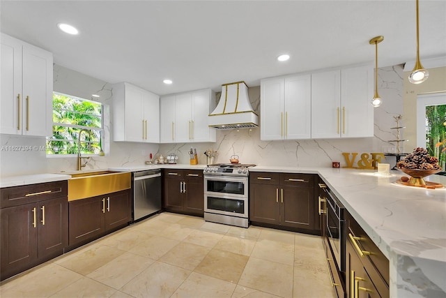 7949 NW 188th Ter, Hialeah, FL 33015 - kitchen with stainless steel appliances, premium range hood, dark brown cabinetry, white cabinetry, and decorative backsplash