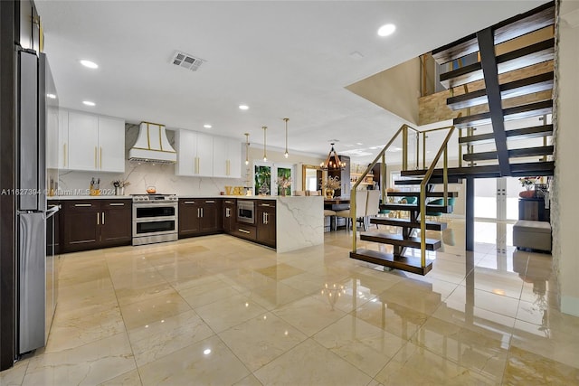 7949 NW 188th Ter, Hialeah, FL 33015 - kitchen with stainless steel appliances, premium range hood, a peninsula, decorative backsplash, and white cabinets