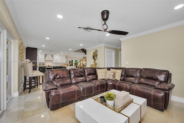 tiled living room featuring a textured ceiling, ceiling fan, and ornamental molding