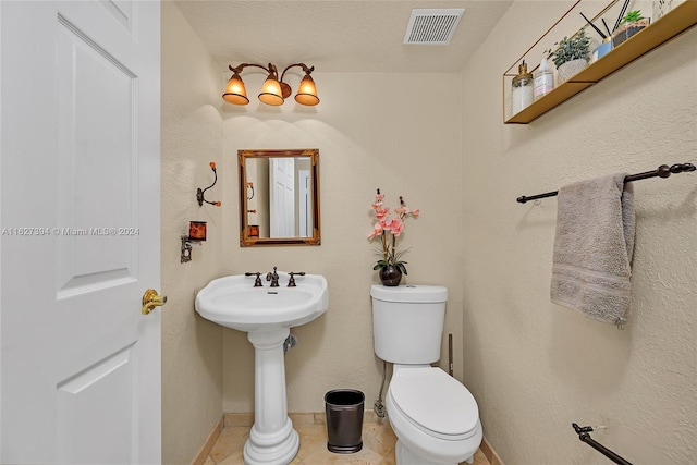 bathroom featuring tile patterned flooring, toilet, and a textured ceiling