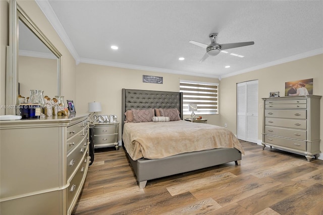 bedroom with a closet, wood-type flooring, ceiling fan, and crown molding