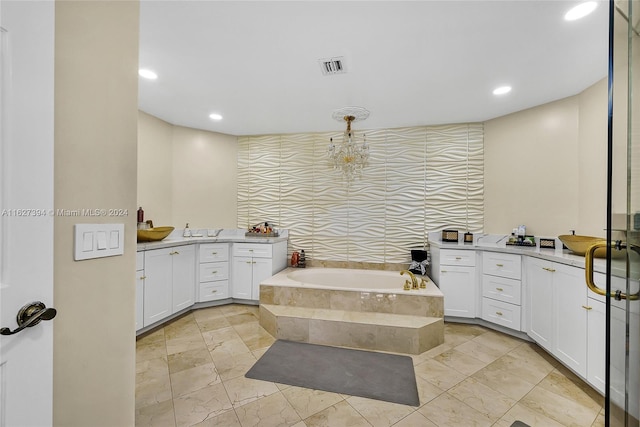 bathroom featuring tiled tub, vanity, and tile patterned floors