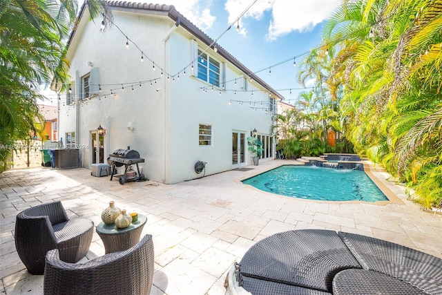 view of pool with an in ground hot tub, a patio area, and area for grilling