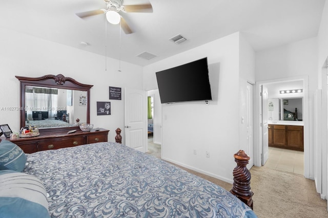 bedroom featuring ensuite bathroom, light tile patterned floors, and ceiling fan