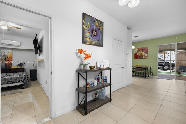 hallway with a wall mounted AC and light tile patterned floors