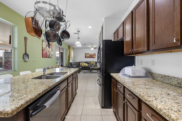 kitchen featuring sink, light tile patterned floors, stainless steel dishwasher, light stone countertops, and ceiling fan