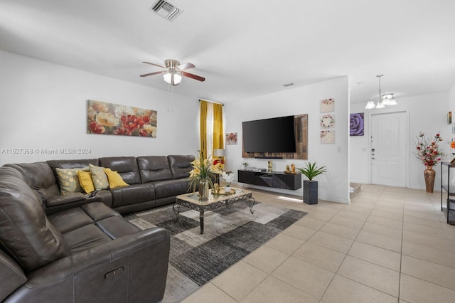 tiled living room featuring ceiling fan with notable chandelier