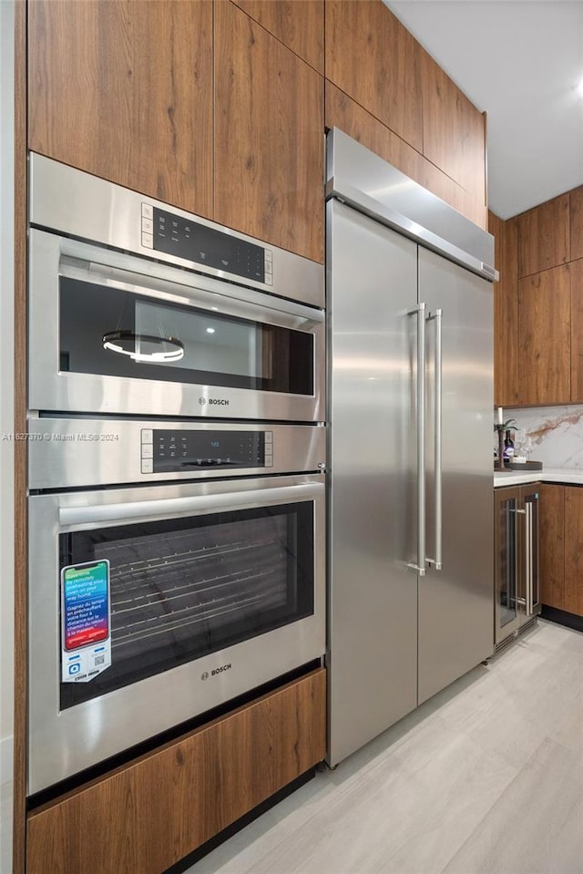 kitchen with backsplash, wine cooler, and appliances with stainless steel finishes