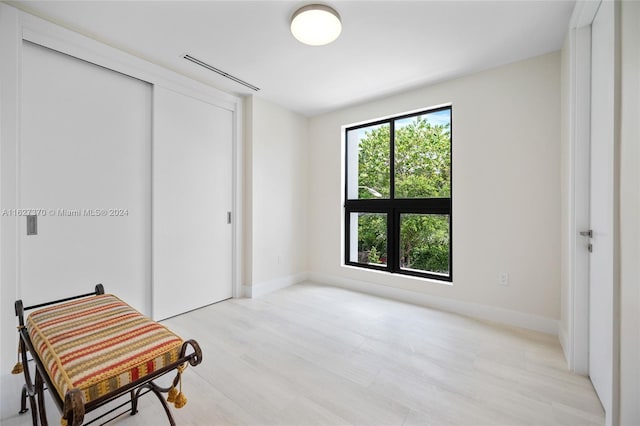 bedroom with light hardwood / wood-style floors and a closet