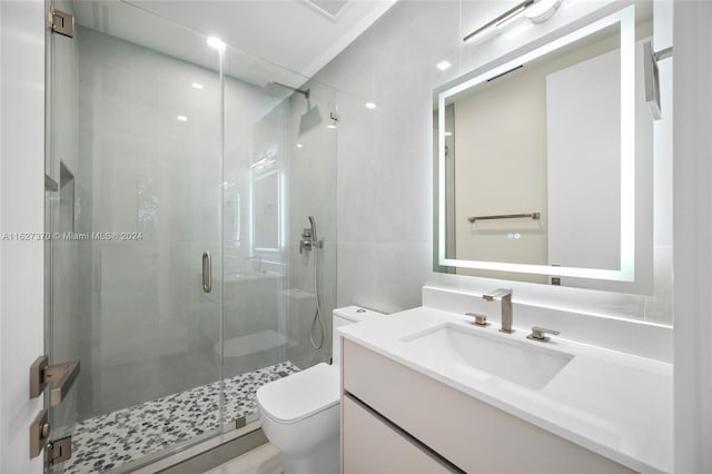 bathroom featuring vanity, toilet, and a shower with door