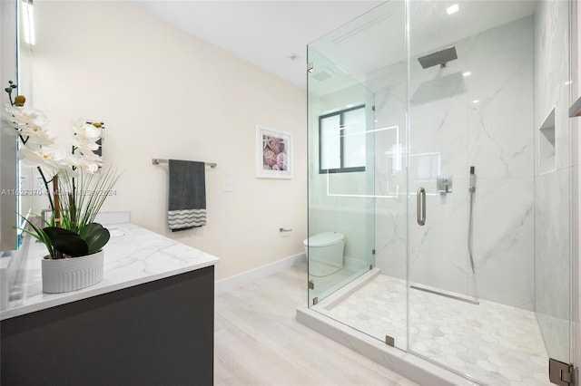 bathroom featuring vanity, toilet, wood-type flooring, and a shower with door