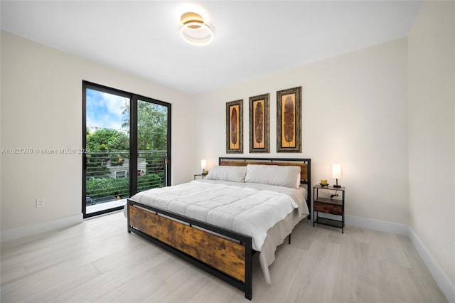 bedroom featuring access to exterior and light wood-type flooring