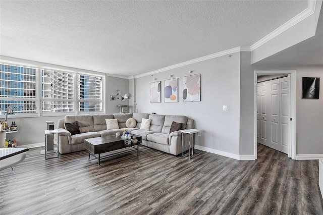 living room with crown molding, a textured ceiling, baseboards, and wood finished floors