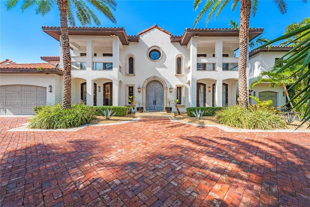 mediterranean / spanish house with a balcony and a garage